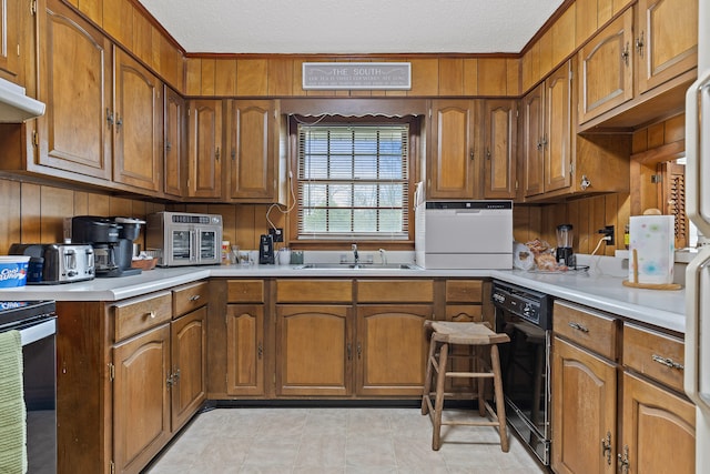 kitchen featuring stainless steel range, a textured ceiling, sink, and dishwasher