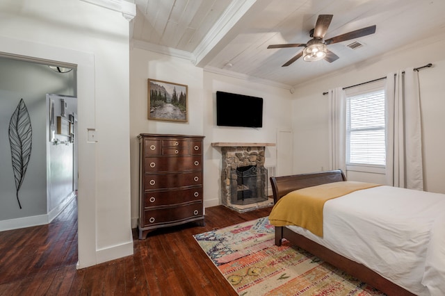 bedroom with dark hardwood / wood-style flooring, ornamental molding, a stone fireplace, and ceiling fan