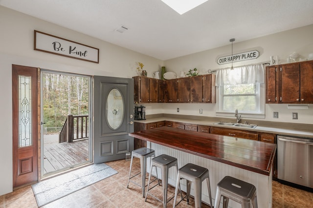 kitchen featuring sink, a healthy amount of sunlight, dishwasher, and a kitchen breakfast bar