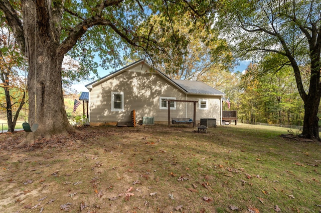 back of property with a wooden deck, a lawn, and central AC unit