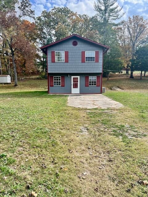 view of front of house with a front yard and a patio