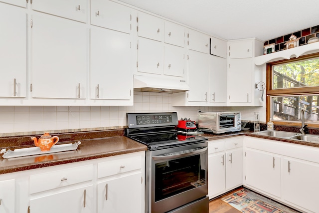 kitchen with decorative backsplash, electric range, white cabinetry, light wood-type flooring, and sink