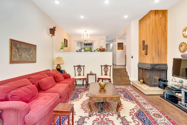 living room with a notable chandelier, a fireplace, and hardwood / wood-style floors