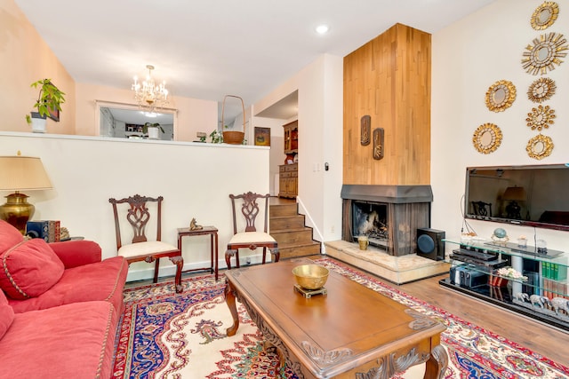 living room with a notable chandelier, wood-type flooring, and a multi sided fireplace