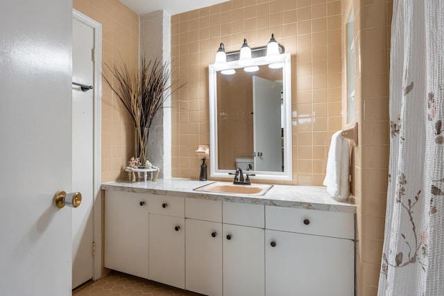 bathroom with tile walls, vanity, and tile patterned flooring