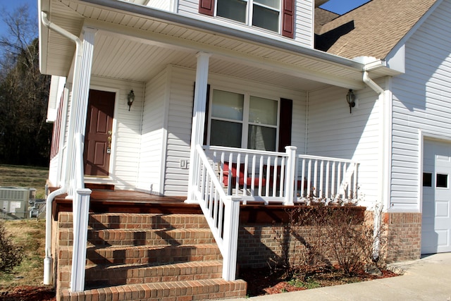 entrance to property featuring a porch and central air condition unit