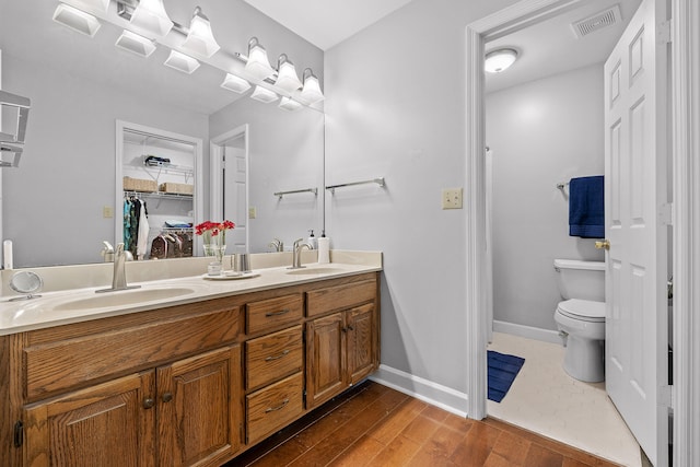 bathroom with vanity, toilet, and wood-type flooring