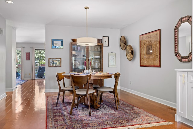 dining space with wood-type flooring