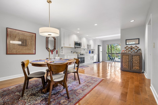 dining area with sink and light wood-type flooring