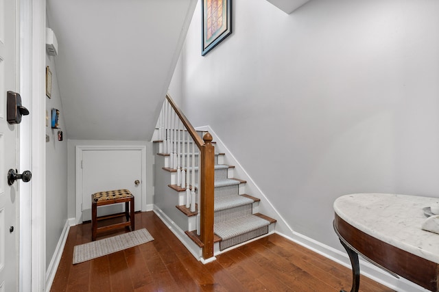 stairs with vaulted ceiling and hardwood / wood-style flooring