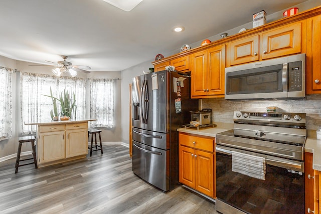 kitchen with tasteful backsplash, dark wood-type flooring, stainless steel appliances, and ceiling fan