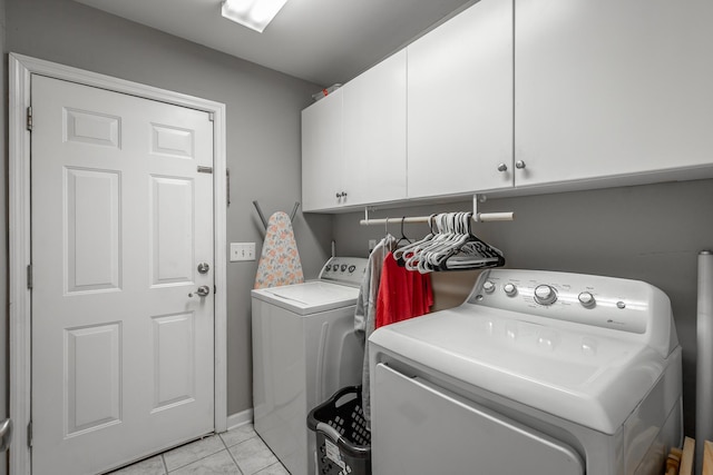 laundry room with separate washer and dryer, cabinets, and light tile patterned flooring