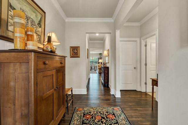 hallway with crown molding, dark wood finished floors, and baseboards