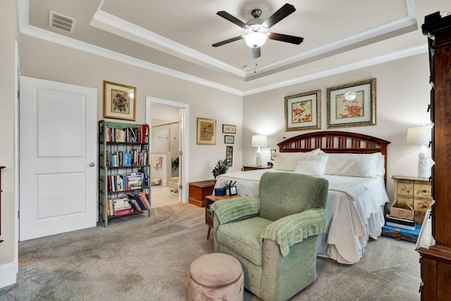 carpeted bedroom featuring connected bathroom, a tray ceiling, visible vents, and crown molding