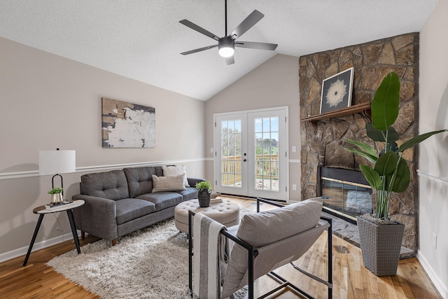 living room with french doors, a fireplace, a textured ceiling, and hardwood / wood-style flooring