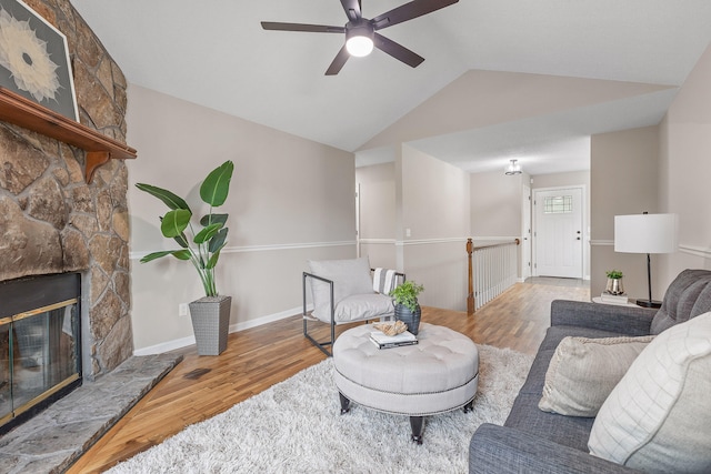 living room with lofted ceiling, hardwood / wood-style floors, ceiling fan, and a fireplace