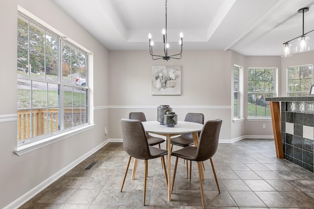 dining space with a chandelier, tile patterned flooring, and a raised ceiling