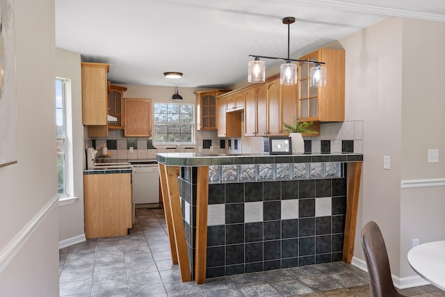 kitchen featuring a chandelier, decorative light fixtures, white dishwasher, decorative backsplash, and kitchen peninsula