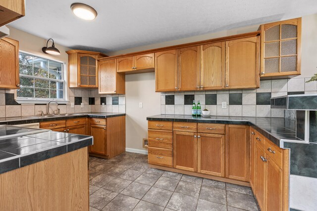 kitchen featuring tile patterned flooring, sink, and decorative backsplash