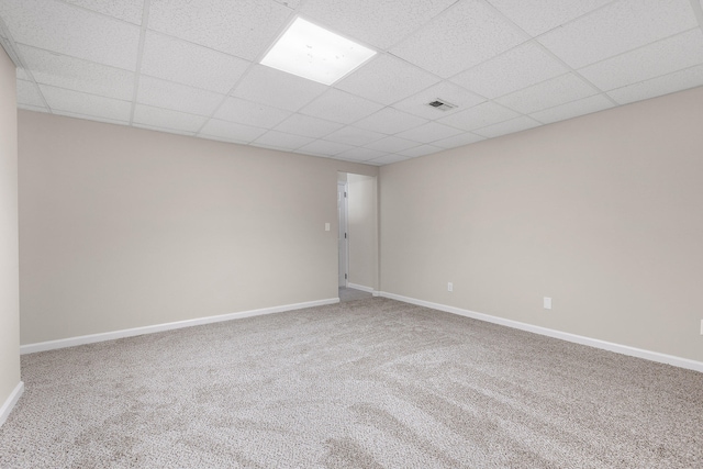 spare room featuring carpet flooring and a paneled ceiling