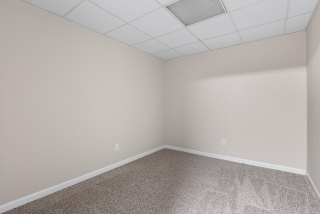 carpeted empty room with a paneled ceiling