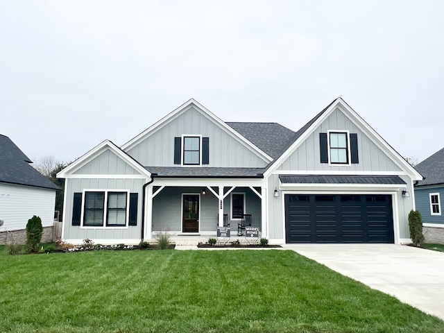 view of front of house featuring a front yard, a garage, and covered porch