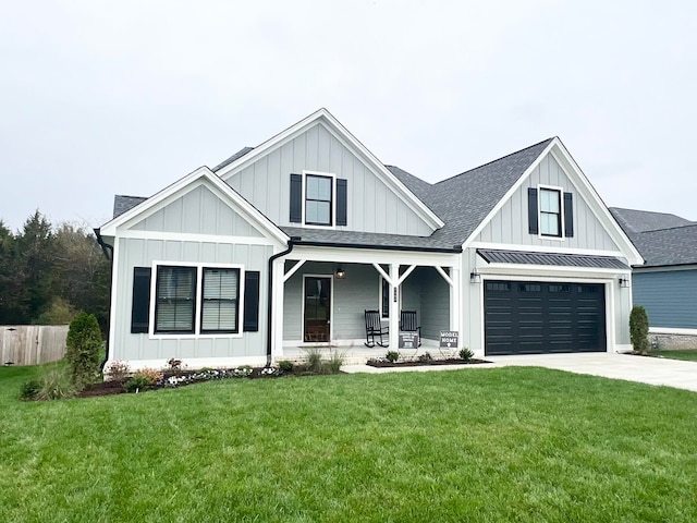 view of front of house with a front yard, a garage, and covered porch