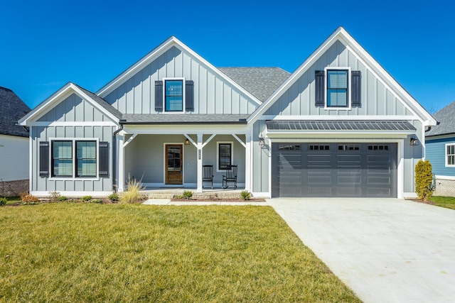 modern inspired farmhouse with covered porch, a shingled roof, driveway, board and batten siding, and a front yard