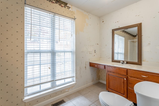 bathroom with walk in shower, vanity, toilet, and tile patterned flooring