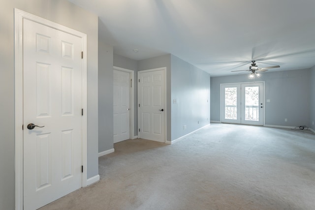 unfurnished room featuring french doors, light colored carpet, and ceiling fan