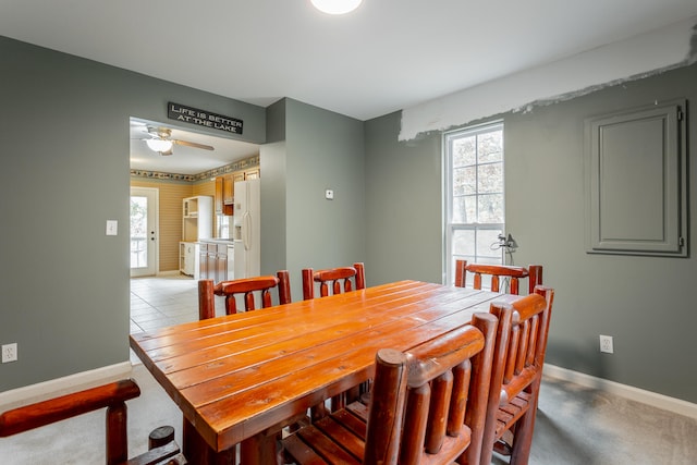 dining space featuring light colored carpet and ceiling fan