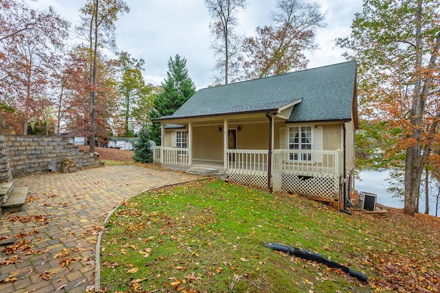 back of property with a lawn, central AC, and covered porch