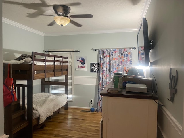 bedroom featuring ornamental molding, hardwood / wood-style flooring, and ceiling fan