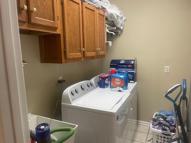 laundry room featuring cabinets, light tile patterned flooring, washer and dryer, and sink