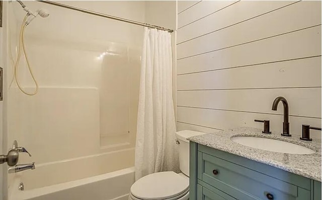 full bathroom featuring shower / tub combo with curtain, vanity, toilet, and wooden walls