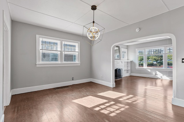 unfurnished living room with a chandelier and wood-type flooring