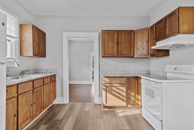 kitchen featuring light hardwood / wood-style floors, light stone countertops, sink, and electric stove