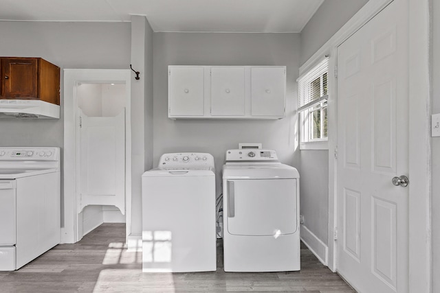 clothes washing area with light hardwood / wood-style flooring and washer and dryer