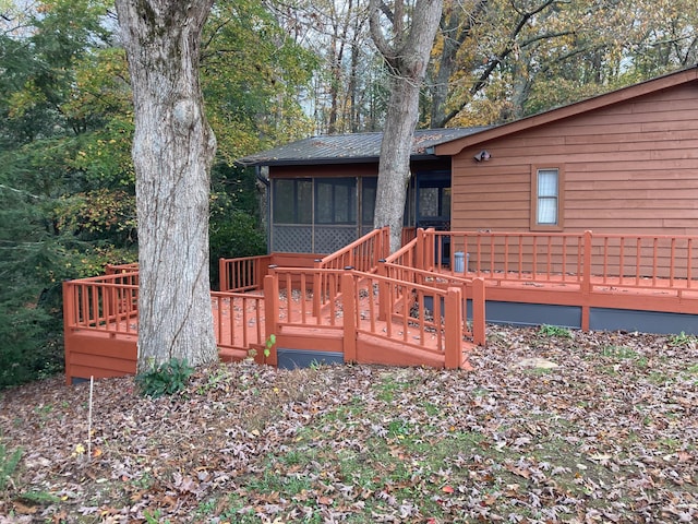 exterior space featuring a sunroom and a wooden deck