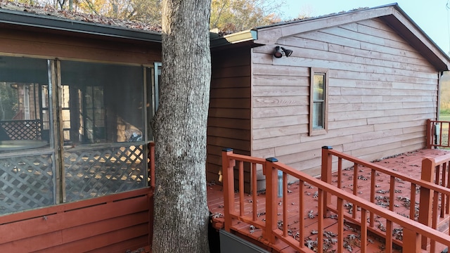 view of property exterior with a deck and a sunroom