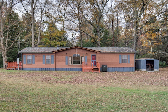 view of front of house with a storage unit and a front yard