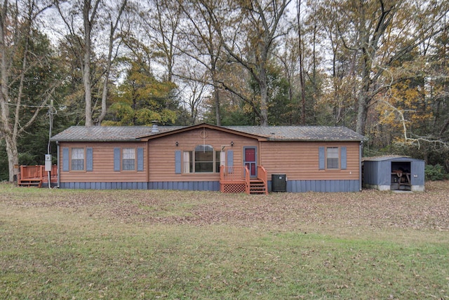 134 Old Spring Rd, Rising Fawn, GA 30738 - manufactured / mobile home with a front yard, a storage unit, an outbuilding, and view of scattered trees
