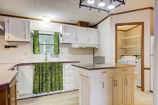 134 Old Spring Rd, Rising Fawn, GA 30738 - kitchen featuring washer and clothes dryer, ornamental molding, white cabinetry, a textured ceiling, and light wood-style flooring