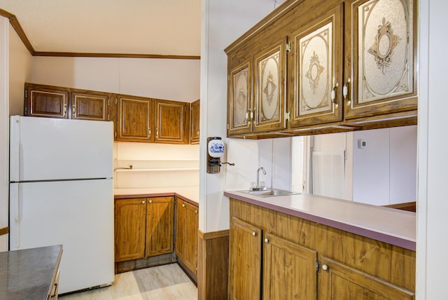 134 Old Spring Rd, Rising Fawn, GA 30738 - kitchen with freestanding refrigerator, a sink, brown cabinets, light countertops, and ornamental molding