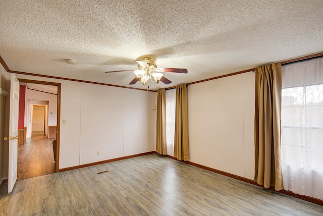 spare room featuring crown molding, light hardwood / wood-style floors, a textured ceiling, and ceiling fan