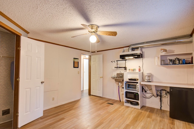 interior space with light wood-type flooring, a textured ceiling, ceiling fan, and crown molding