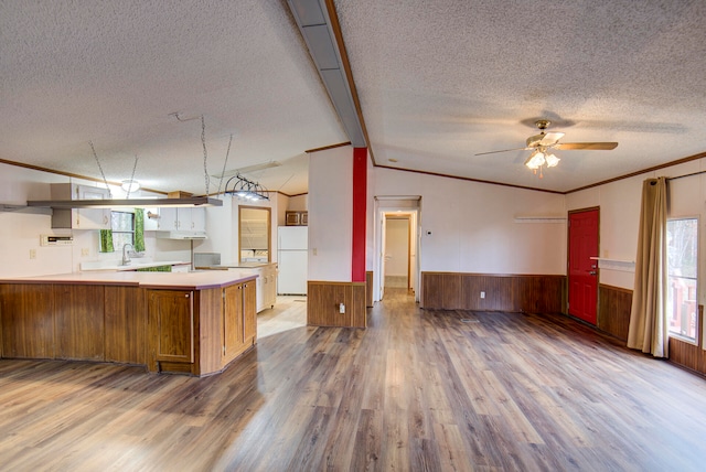 kitchen featuring kitchen peninsula, wood-type flooring, a textured ceiling, and white fridge