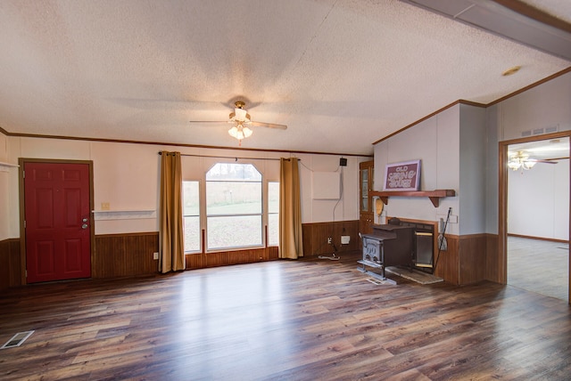 living room featuring hardwood / wood-style flooring, ceiling fan, a textured ceiling, a wood stove, and lofted ceiling