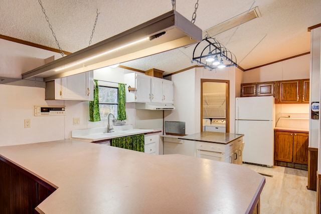 kitchen with white fridge, white cabinetry, a textured ceiling, lofted ceiling, and a center island