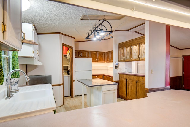 kitchen with white fridge, a textured ceiling, pendant lighting, sink, and lofted ceiling